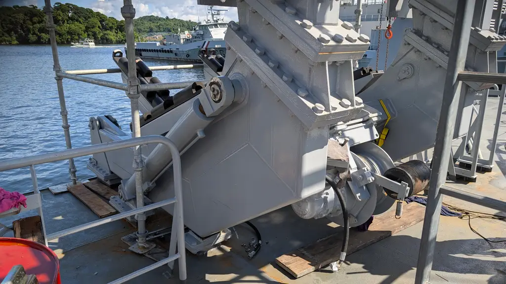 Davit on deck, with ships on the water behind it
