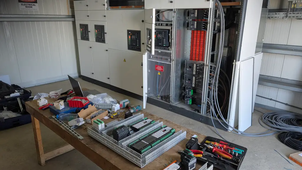 Switchboard room with cabinets, a laptop and parts on the table