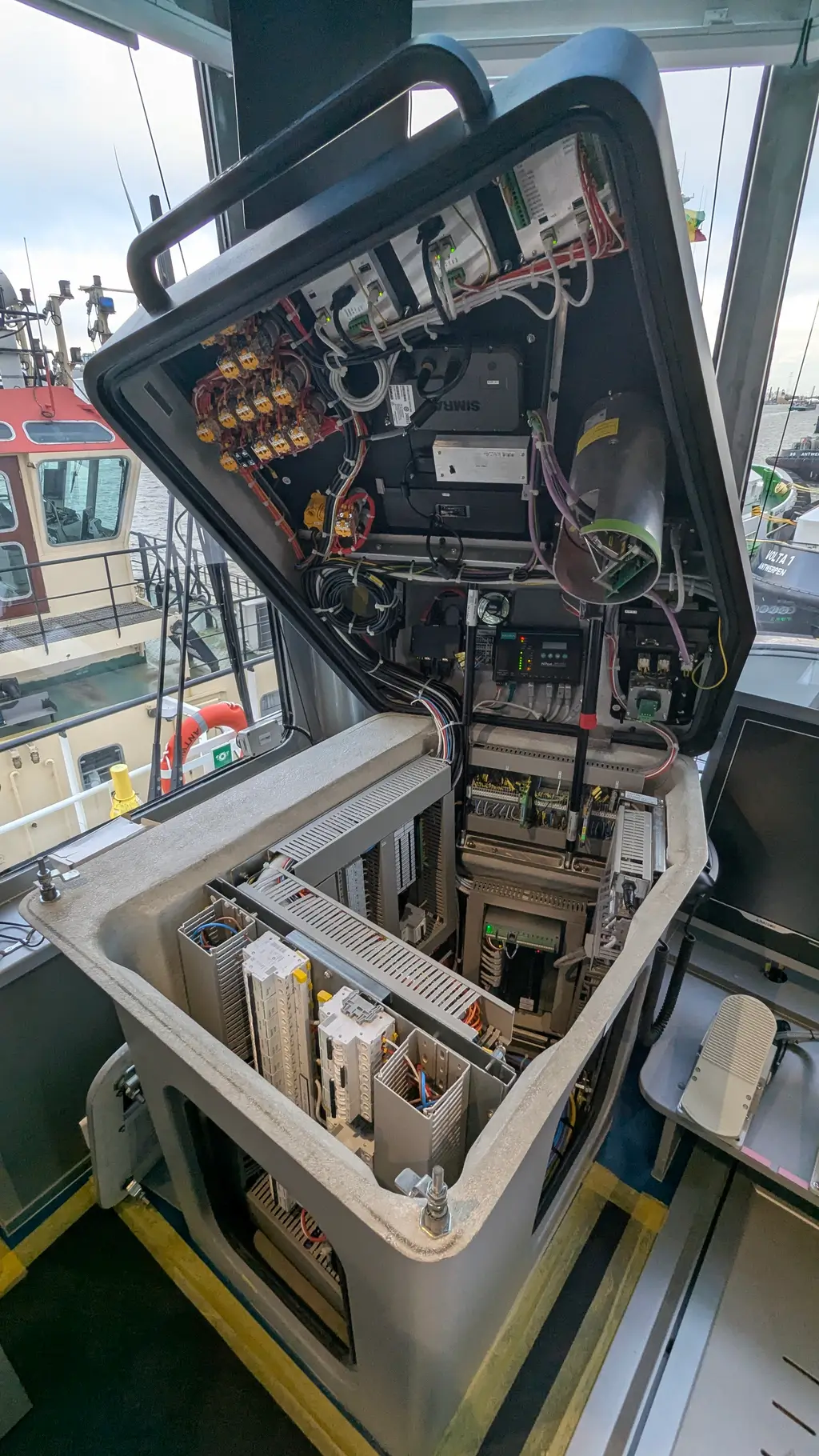 Open console on the bridge of a tug, with the wiring exposed